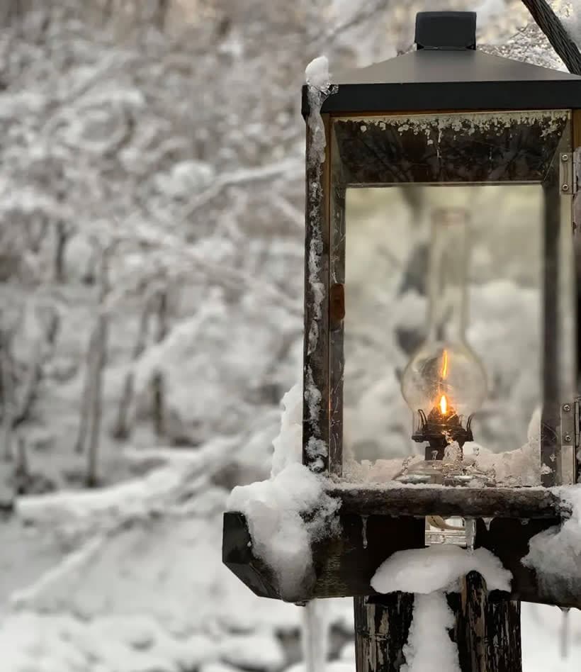 A light that is on a pole in the snow