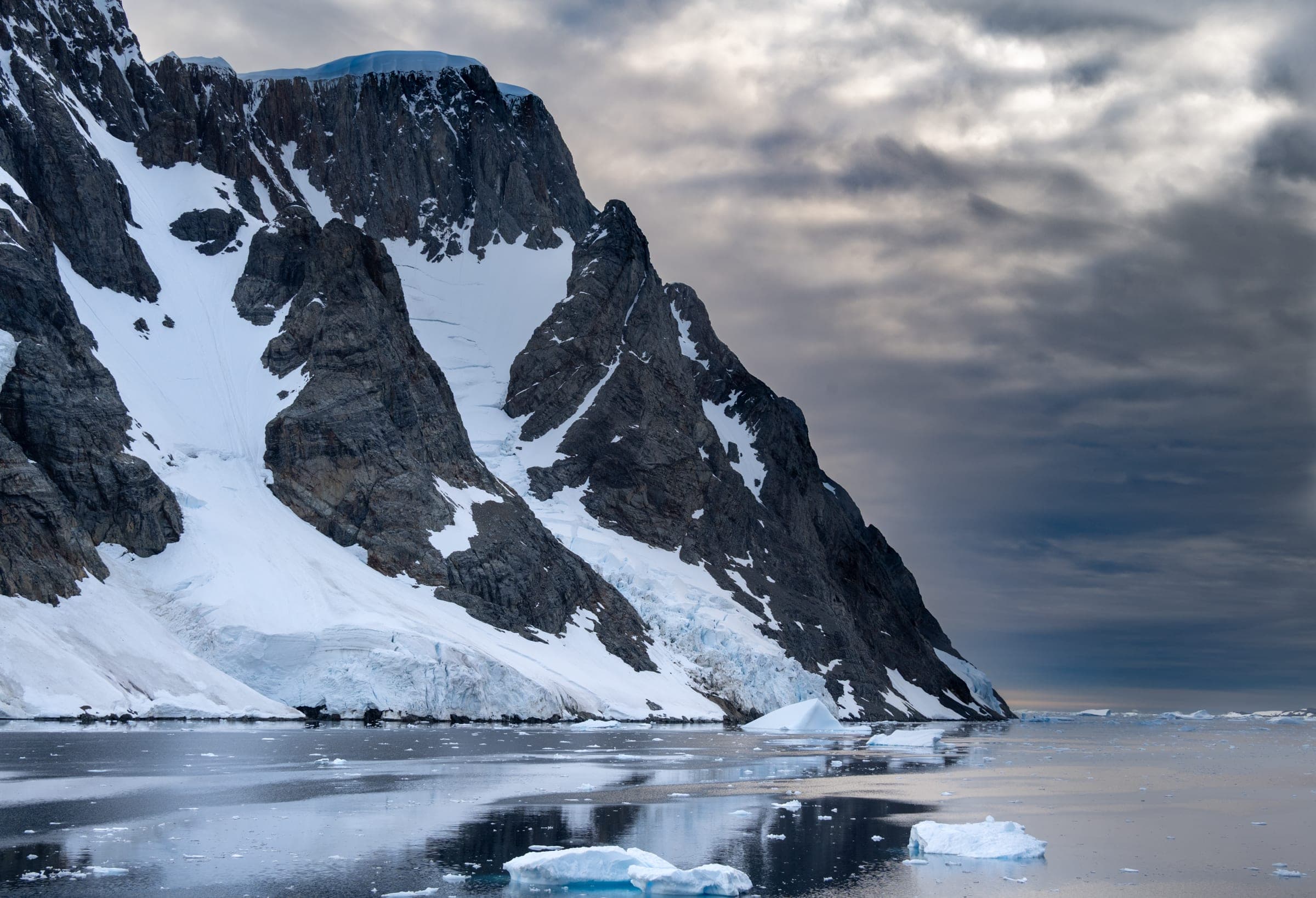 A mountain with snow and ice floating in the water