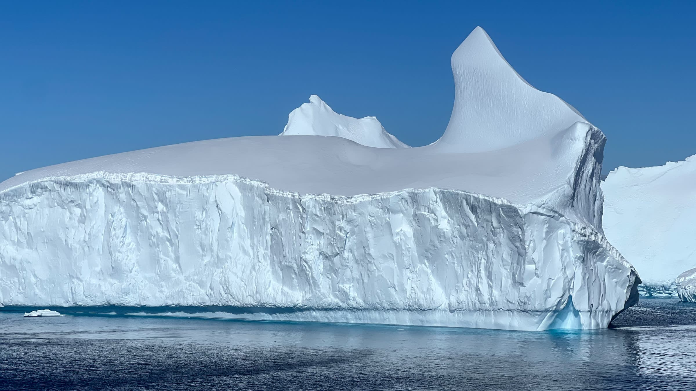 A large iceberg floating in the middle of the ocean