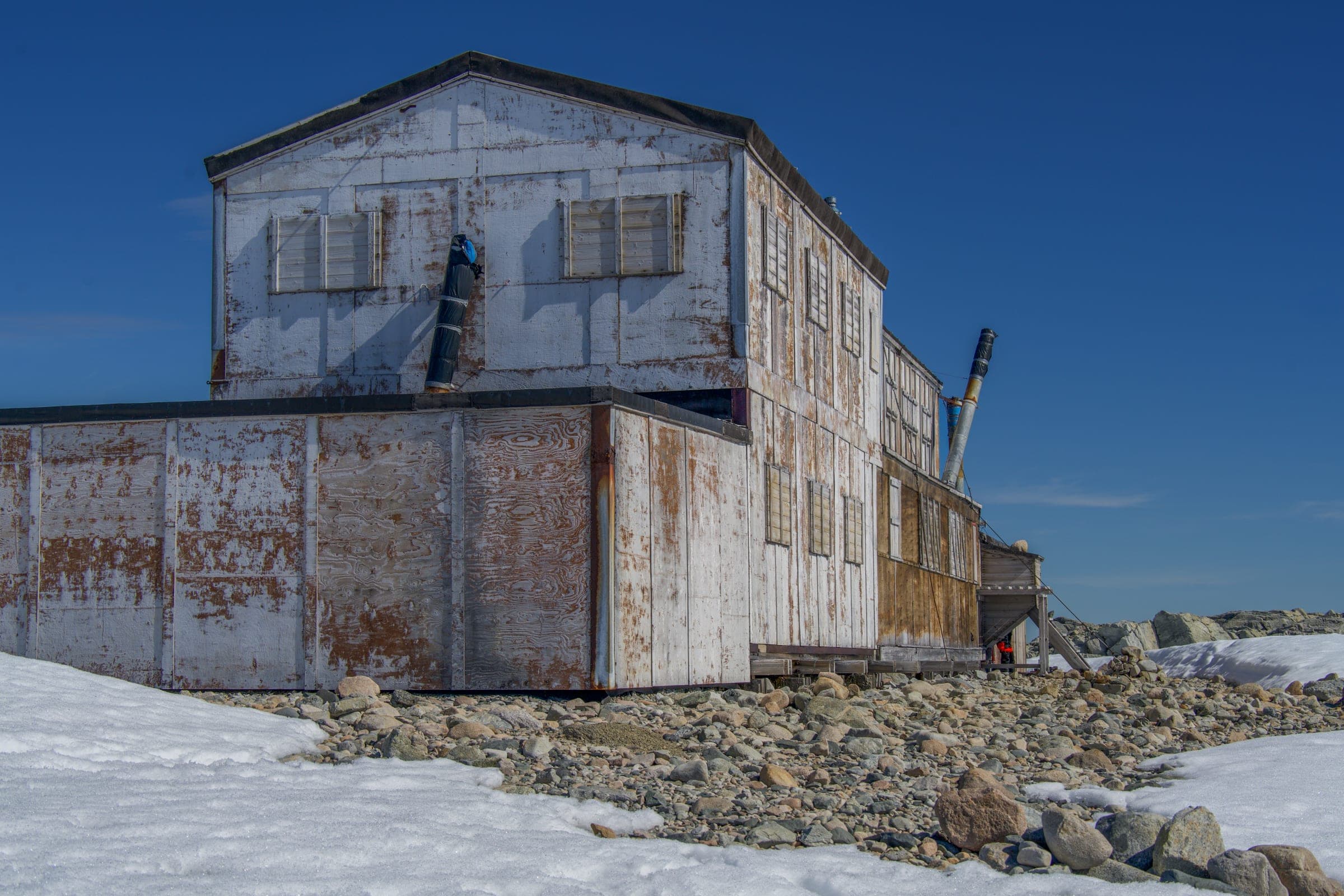 An old building sitting on top of a pile of snow