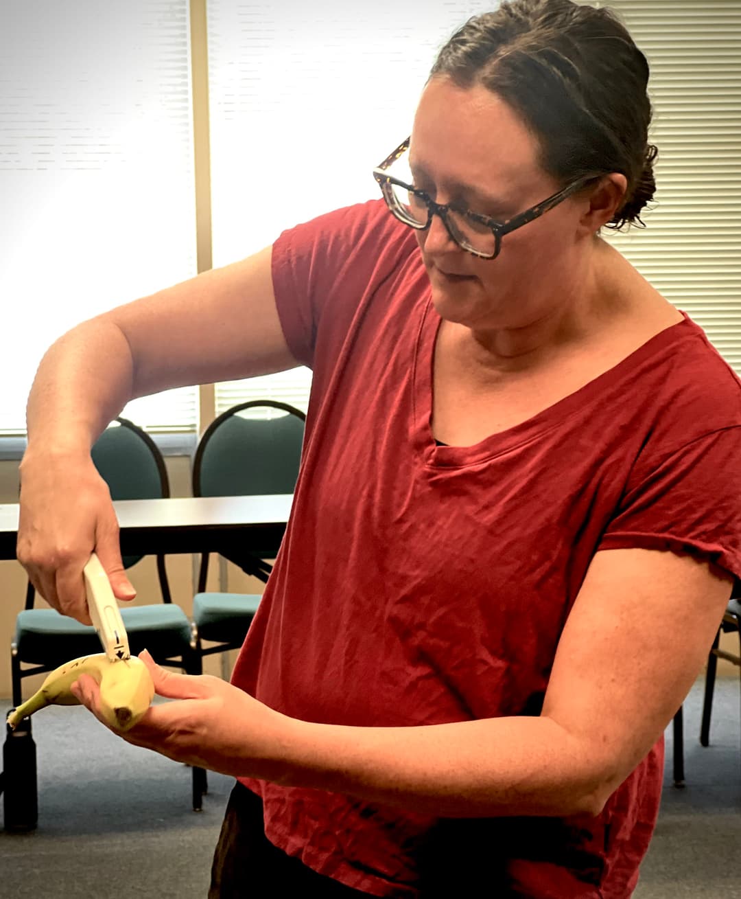 A woman cutting a banana with a knife