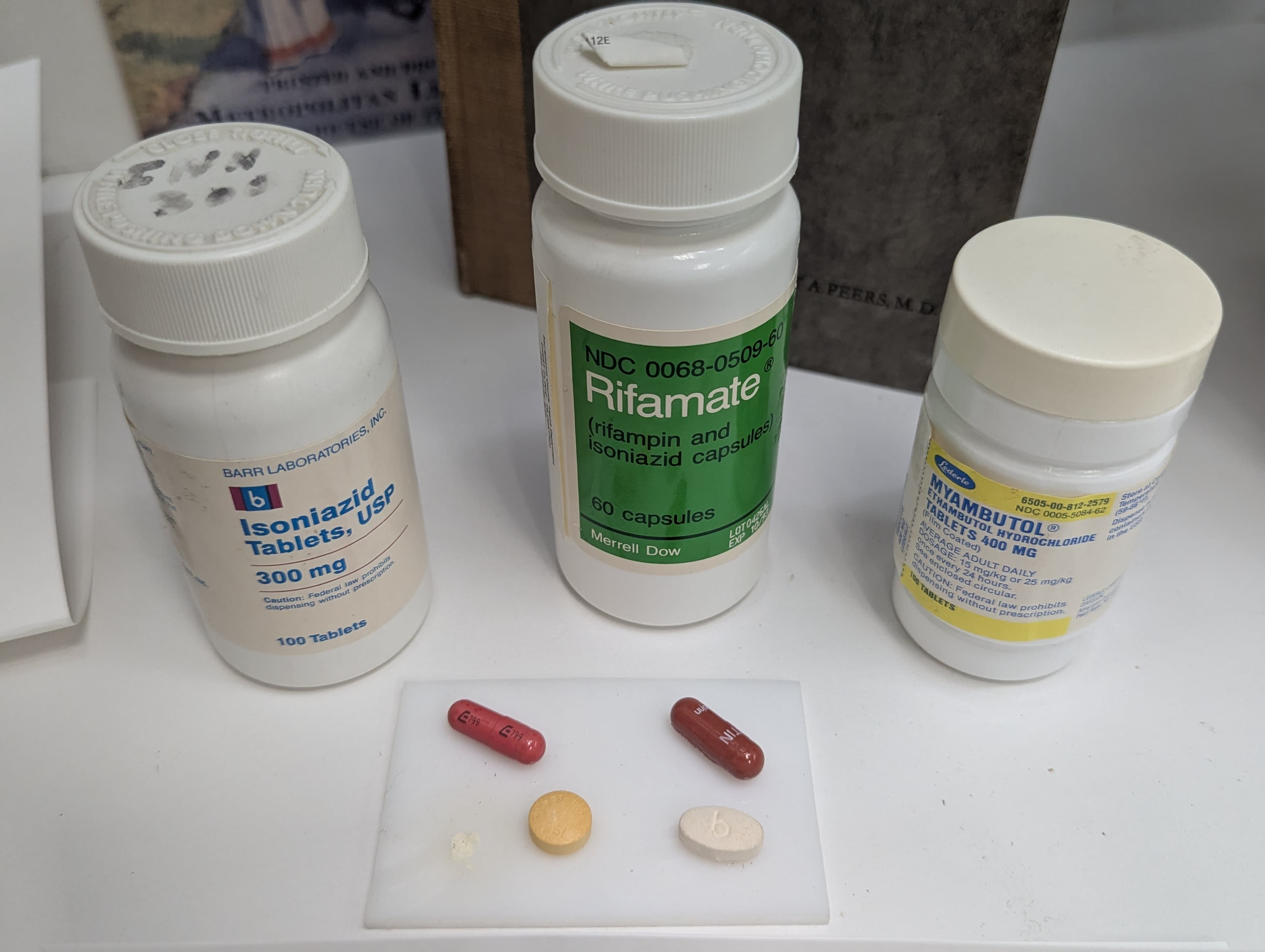 A table topped with three bottles of pills