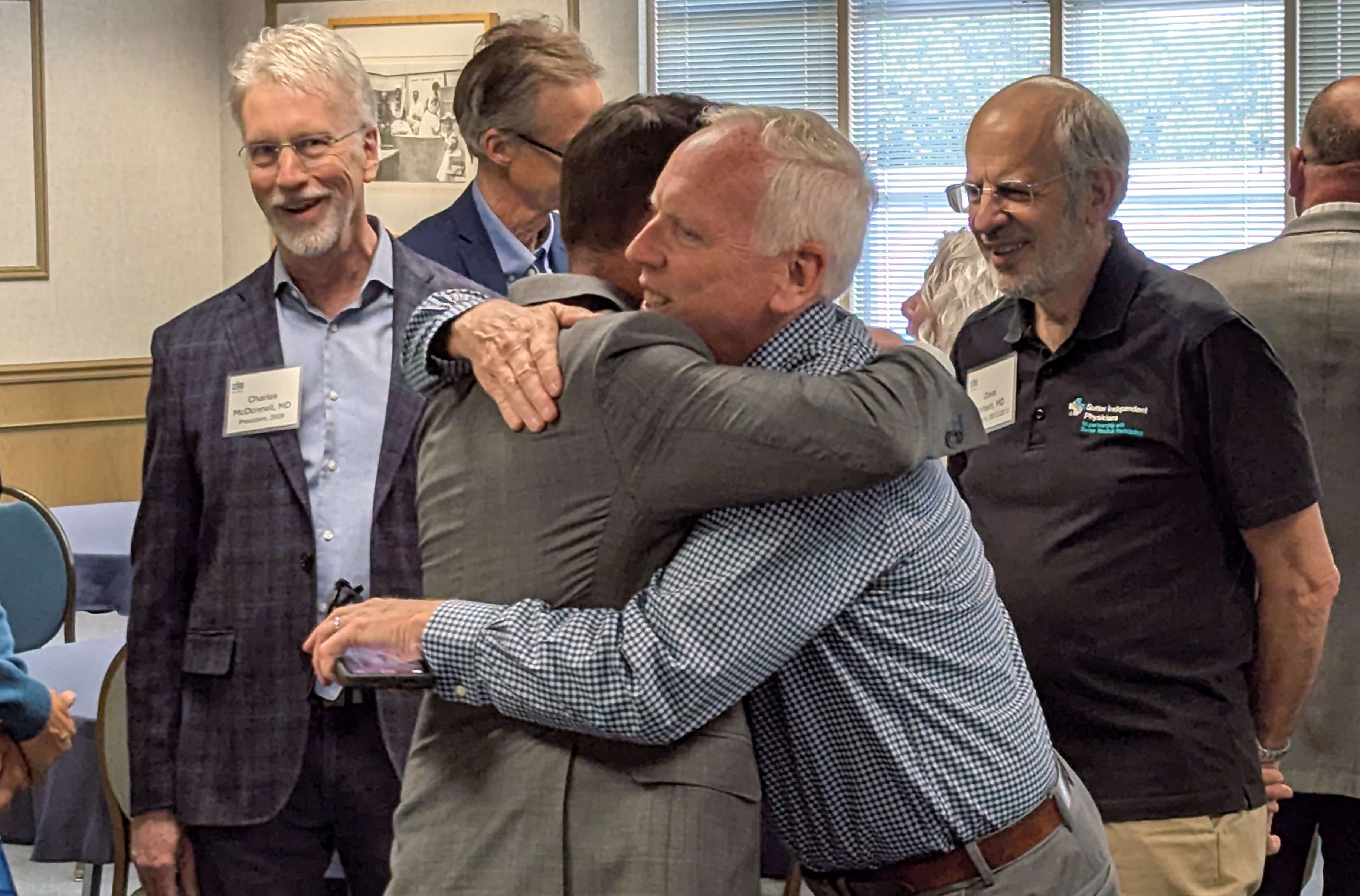 A group of men hugging each other in a room