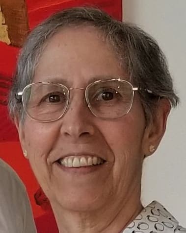 A woman wearing glasses standing next to a man