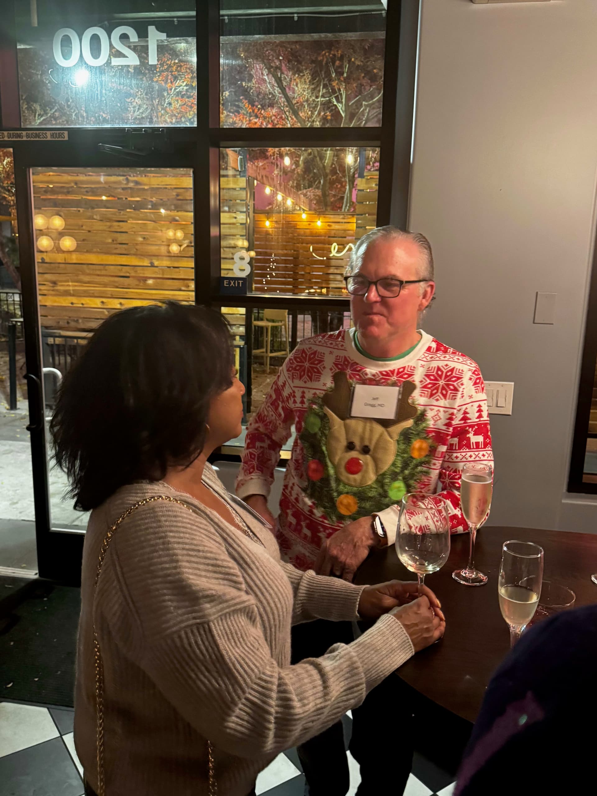 A man and woman standing at a table with wine glasses