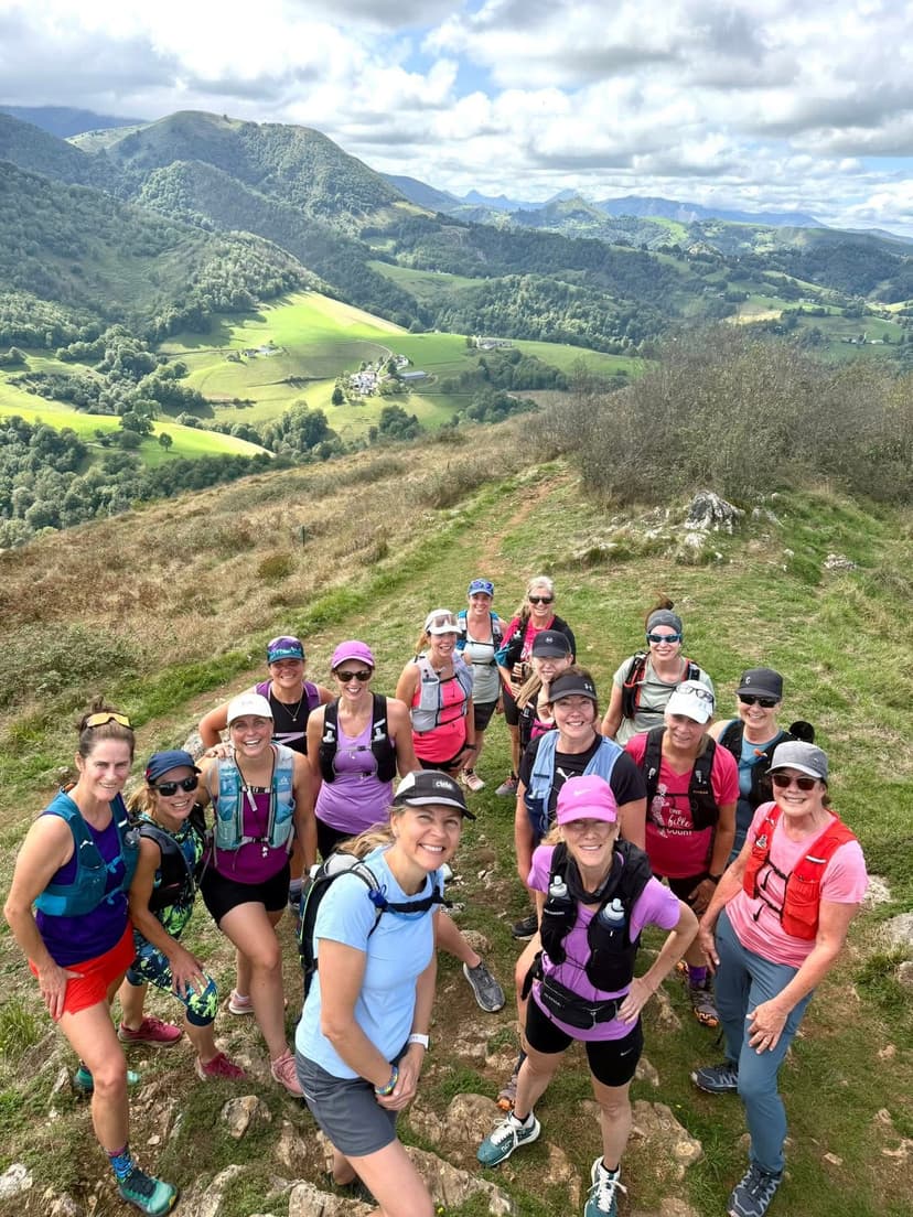 A group of people standing on top of a lush green hillside