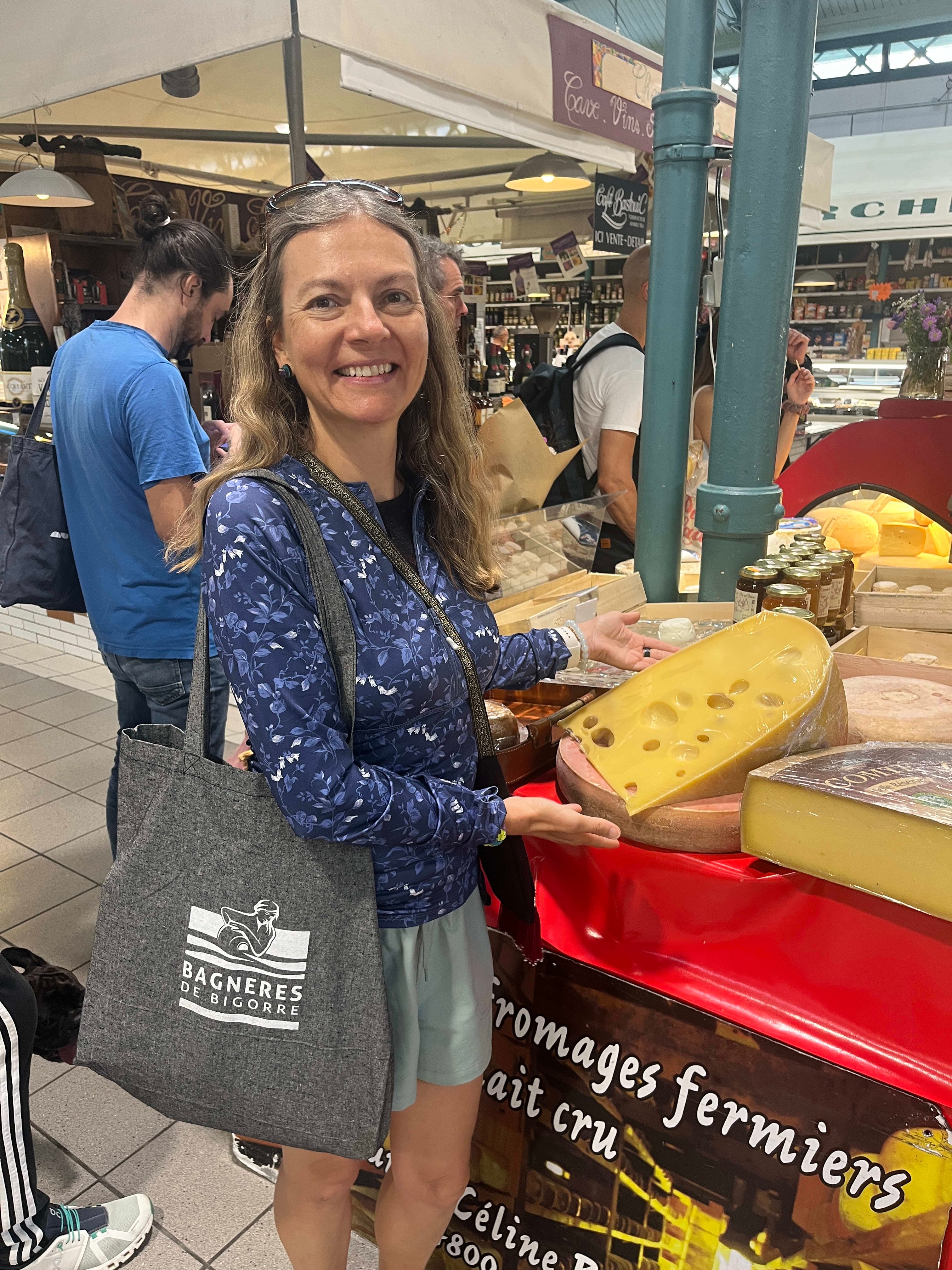 A woman standing in front of a display of cheese