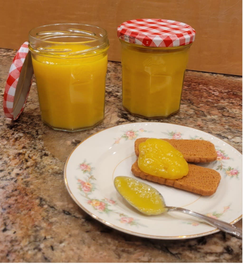 A plate of food and a jar of jam on a table
